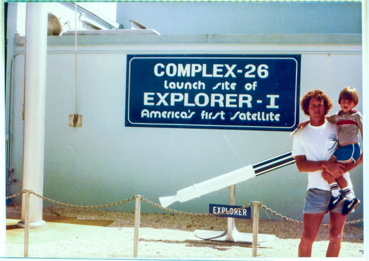 James MacLaren holding his son Kai, in front of the Explorer-I replica by the blockhouse at Complex 26, Air Force Space Museum, Cape Canaveral, Florida. Photo taken circa 1982.